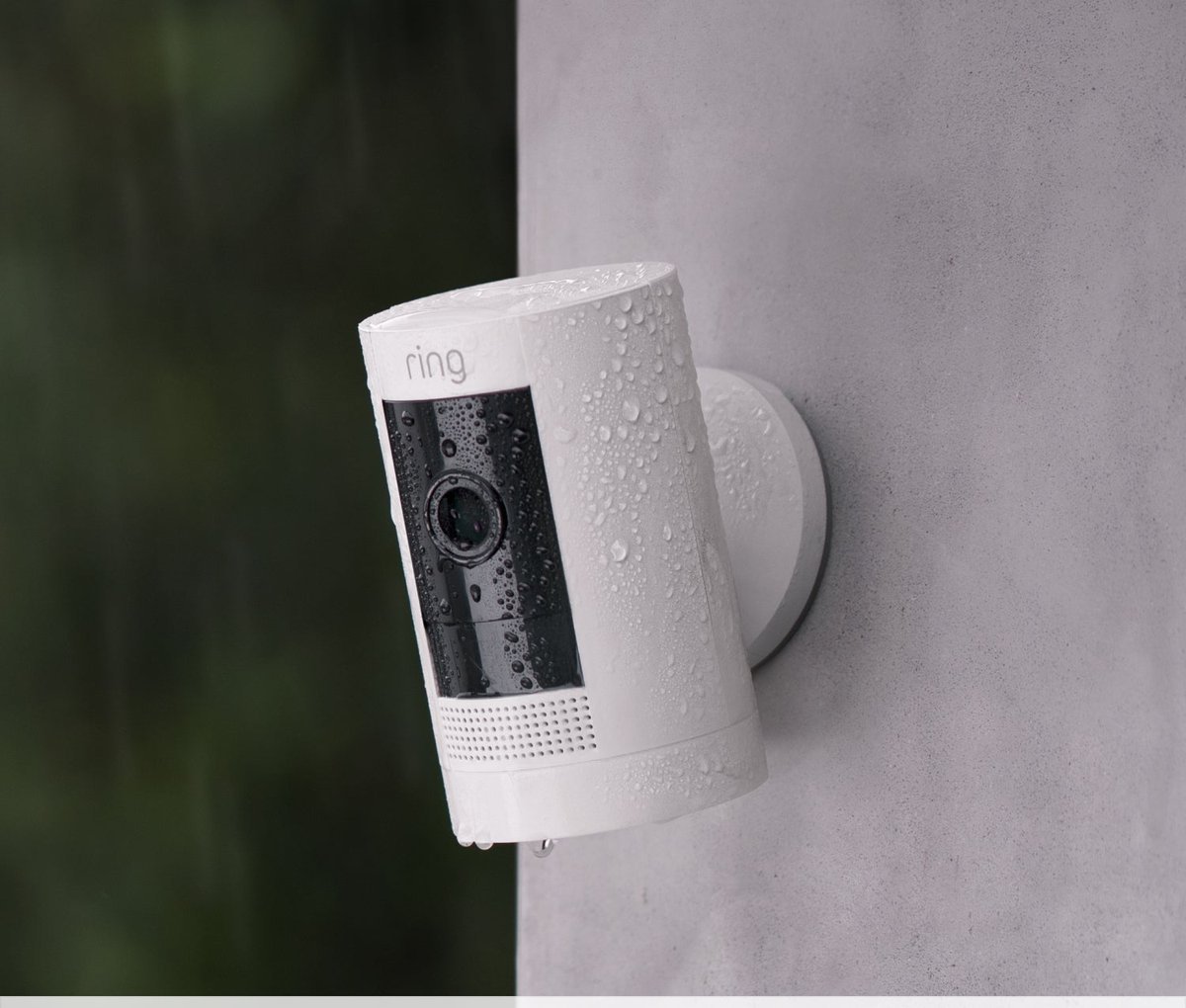 Ring Outdoor Cam (Stick Up Cam) Battery in white mounted on an outdoor wall in the rain