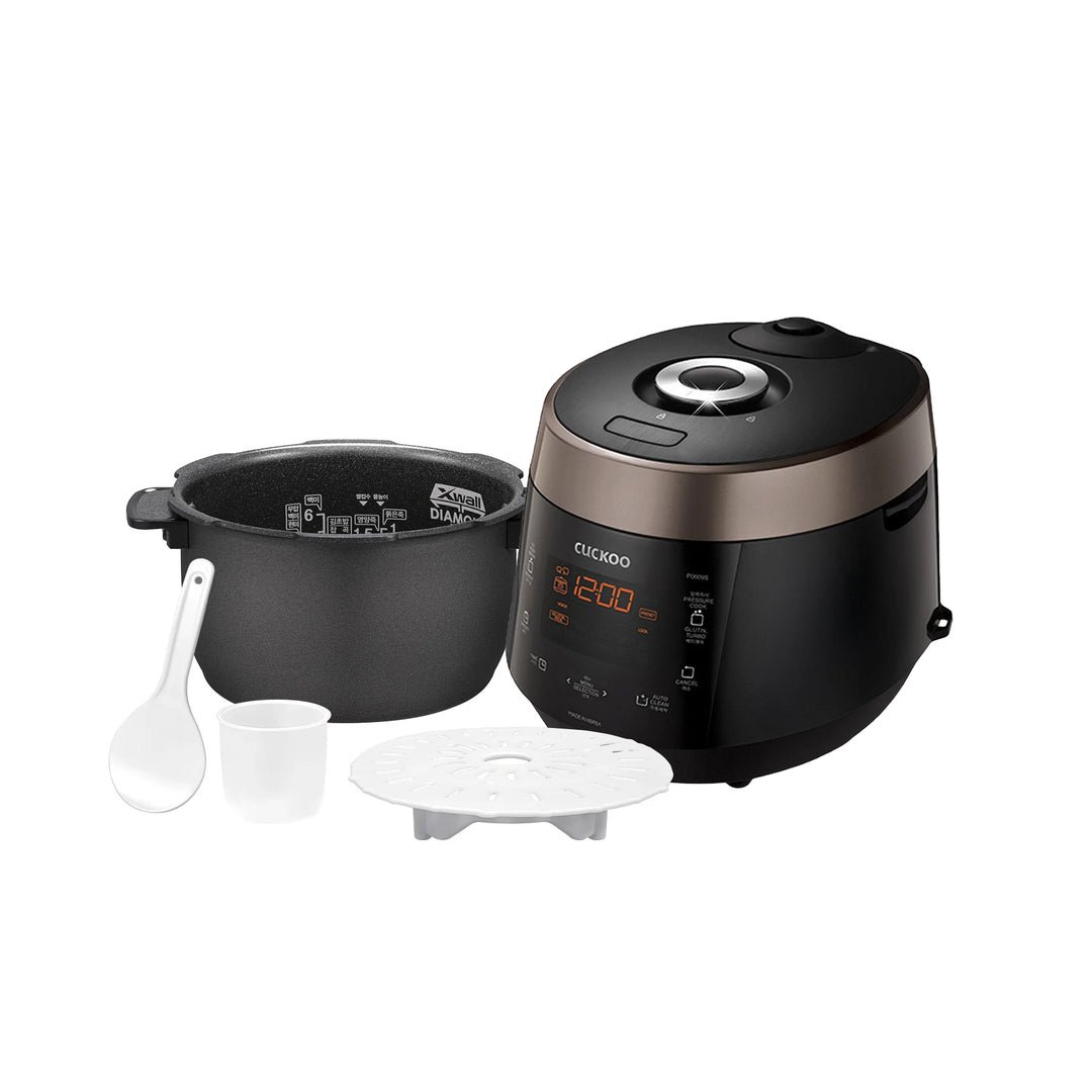 Cuckoo CRP-P0609S black and copper unit beside its X-Wall Diamond inner pot, rice paddle, measuring cup, and steam plate